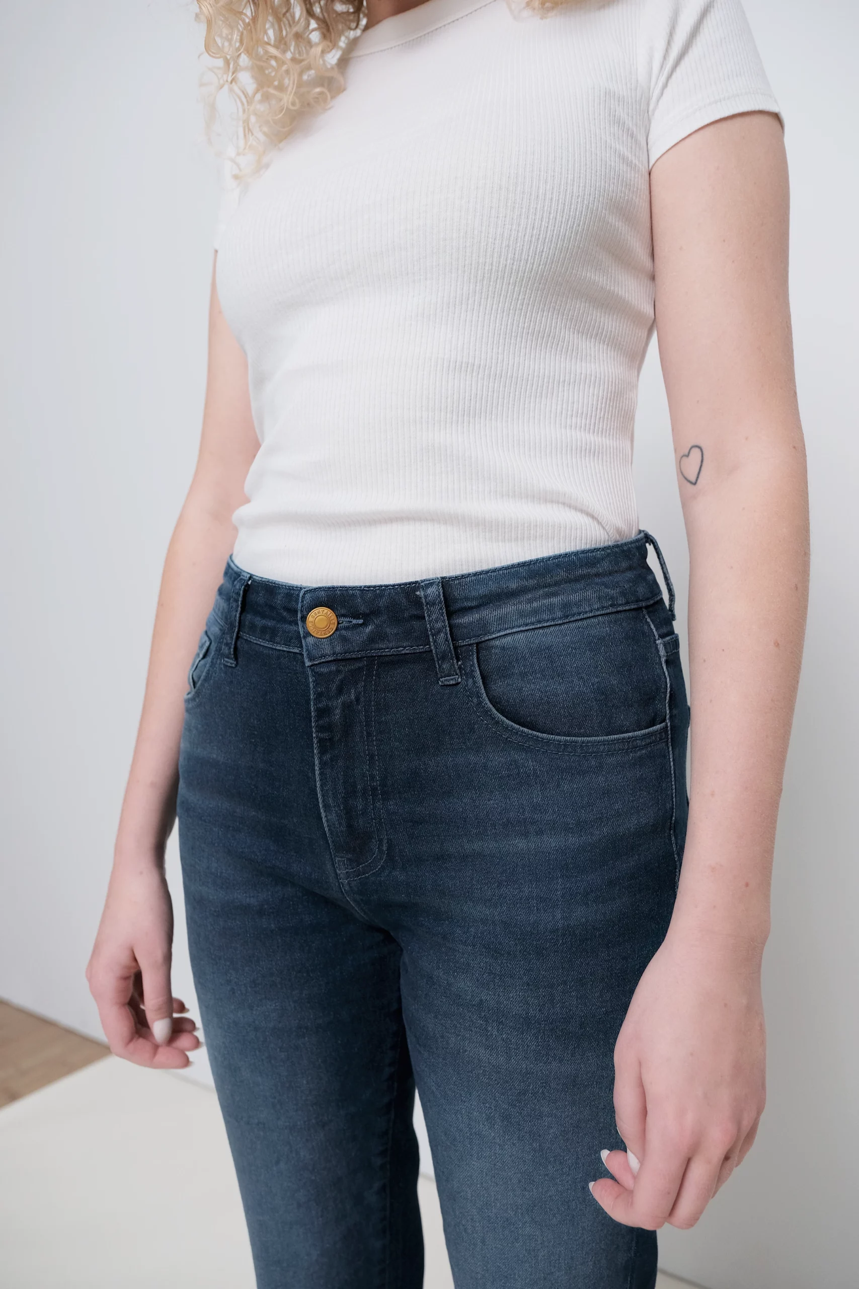 a person wearing jeans and a white tank top
