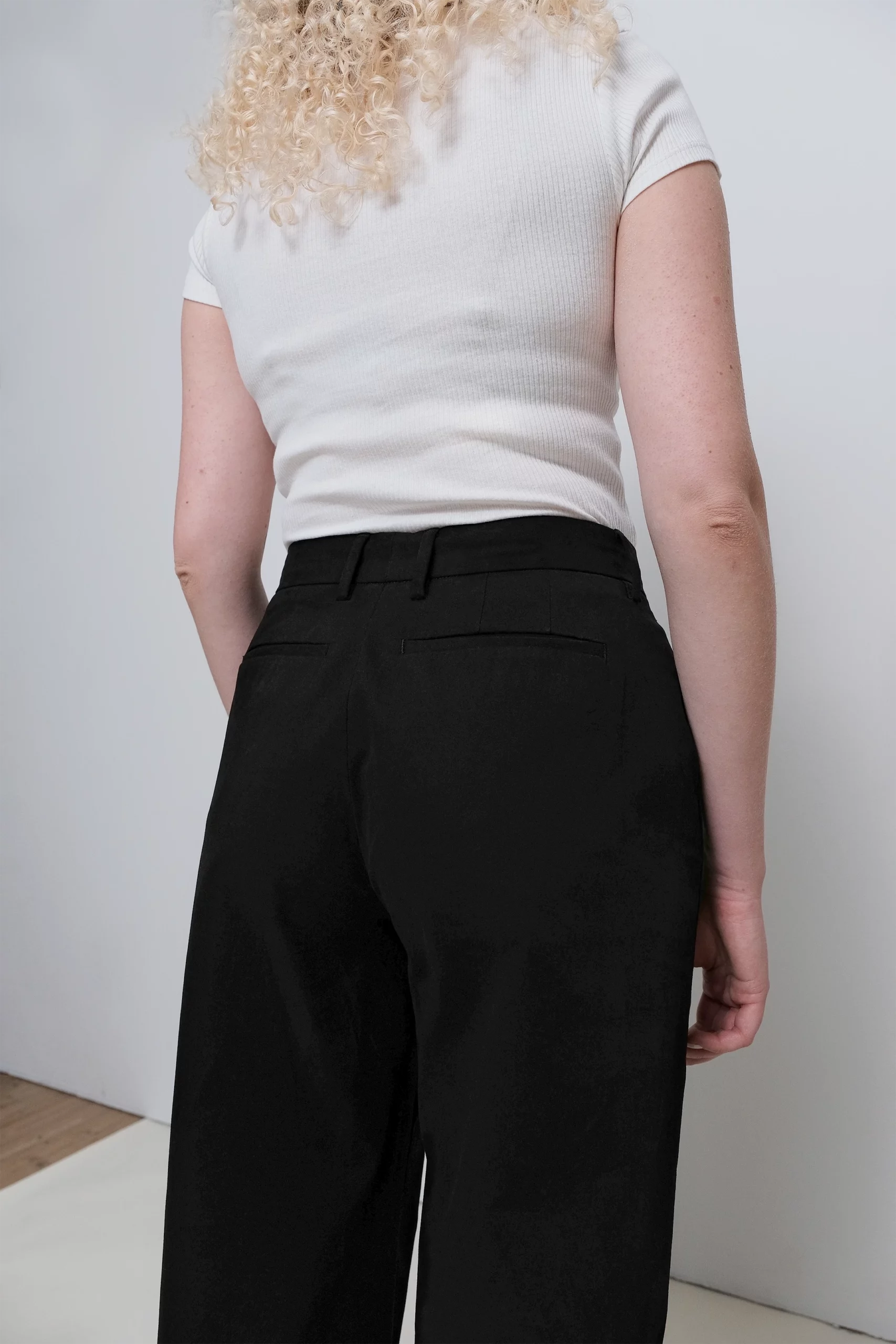 Modell som har på sig Gentaille chinos Orléans svarta bakifrån, detaljbild.