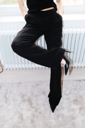 Girl wearing black suit pants with extra long legs