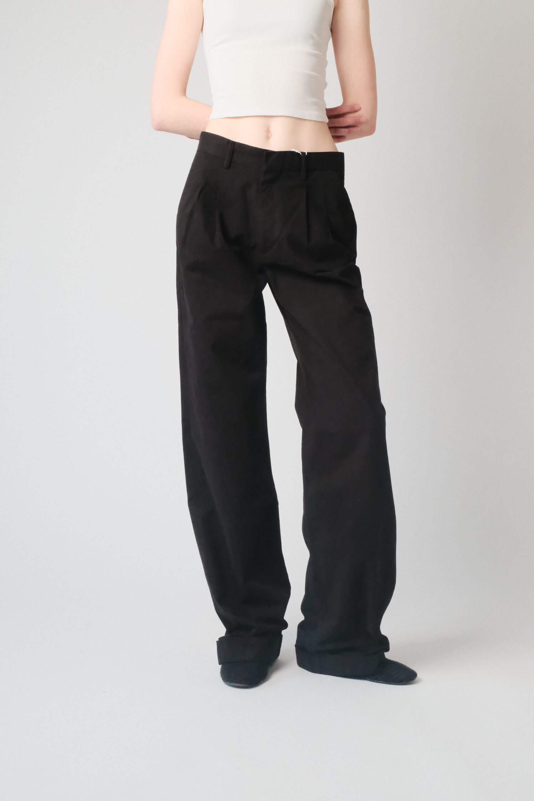 Girl wearing black chino pants with extra long legs