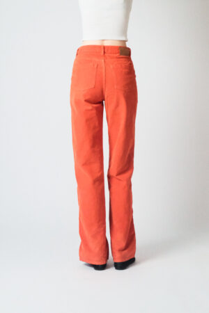 Girl wearing orange corduroy pants with extra long legs